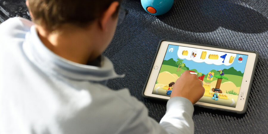 Un bambino impegnato nell'utilizzo di un tablet per scopi di gioco e apprendimento